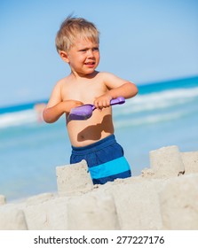 Cute Child Boy Building Sandcastle On The Beach