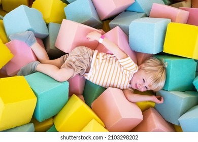 Cute Child Boy Plays With Soft Cubes In The Dry Pool In Play Center