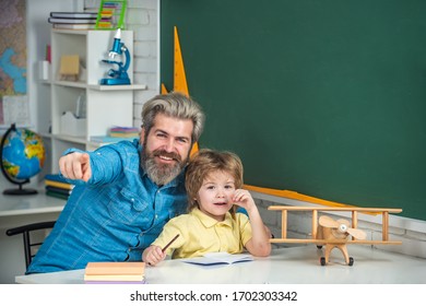 Cute Child Boy With Teacher In Classroom Near Blackboard Desk. Tutoring Agency. Private Kids Tutoring. School Community Partnership Models