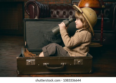 Cute child boy in a travel suitcase playing at home. Childhood. Fantasy, imagination.  - Shutterstock ID 1083336644