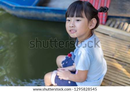 Cute Child girl asian Soaked feet in river Happy smile in Holiday travel