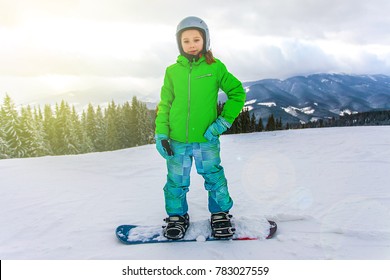 Cute Child Girl Is Snowboarding On The Snow Mountain