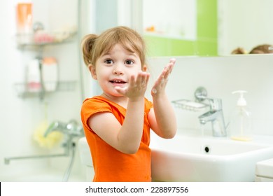 Cute Child Girl Washing Hands In Bathroom