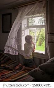 Cute child opening a window for fresh air in the early morning in the village home, happy summertime, healthy vacation and holidays, cozy homely concept, lifestyle emotional portrait