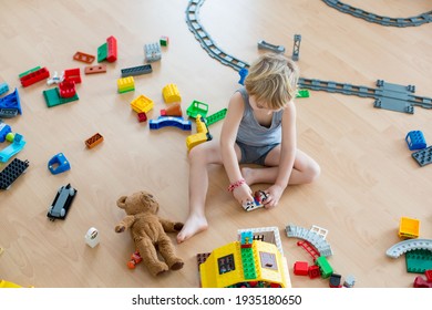 Cute Child, Playing With Colorful Toy Blocks. Little Boy Building House Of Block Toys Sitting On The Floor In Sunny Spacious Bedroom. Educational Game For Toddlers