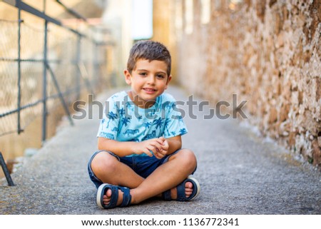 Similar – Cute little boy seated on the wall of a castle