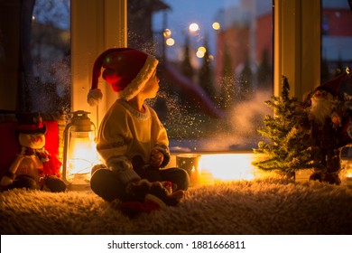 Cute Child, Sitting On A Window, Looking Outdoors For Santa Claus, Christmas Decoration On The Window