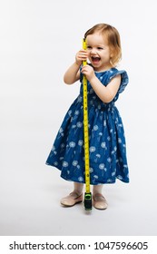 Cute child smiling and holding a measuring tape, they grow fast