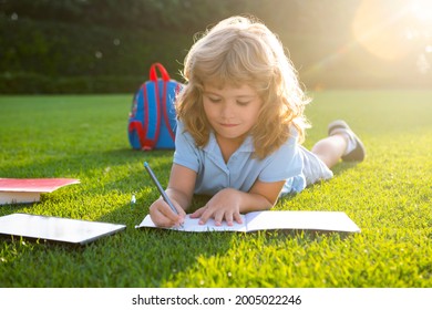 Cute Childr Boy With Books With Pencil Writing On Notebook Outdoors. Summer Camp. Kids Learning And Education Concept. Summer Vacation Homework. Preschool Student Outdoor.