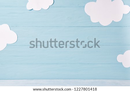 Cute children or baby background, white clouds on the blue wooden background