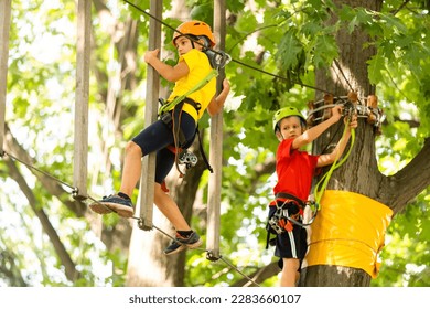 Cute children. Boy and girl climbing in a rope playground structure at adventure park - Powered by Shutterstock