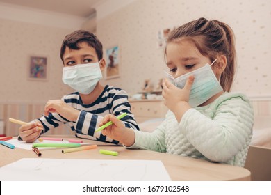 Cute children boy   girl in medical mask is sitting at home in quarantine  Сhildren play constructor after disinfection hands   Entertainment for the children during  quarantine  Self  isolation    