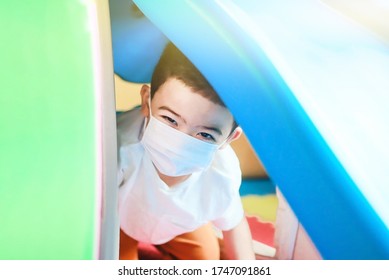 Cute Children Boy Playing Indoor Playground  With Face Mask Protection. Kids Hide And Seek. Self Isolation.