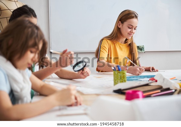 Cute
children drawing clothes patterns in sewing
workshop