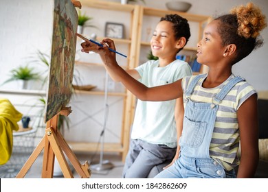 Cute Children Girl And Boy Painting Together. Education, Art, Fun And Creativity Concept.