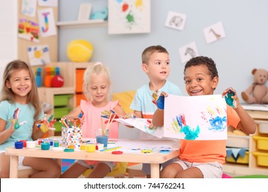 Cute children painting with their palms at table indoor - Shutterstock ID 744762241