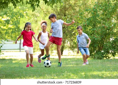 Cute children playing football in park - Shutterstock ID 717236839