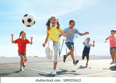 Cute Children Playing Soccer Outdoors On Sunny Day. Summer Camp