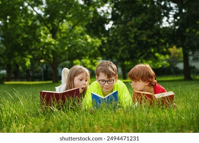 Cute children reading colorful books together outside in the park. - Powered by Shutterstock