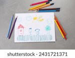 Cute child`s drawing and colorful pencils on grey textured table, flat lay