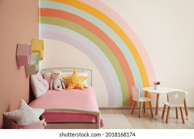 Cute child's room interior with beautiful rainbow painted on wall - Powered by Shutterstock