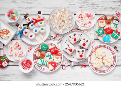 Cute Christmas desserts table scene. Overhead view on a white wood background. Fun holiday baking concept. Cookies, brownies, donuts, cupcakes and sweets. - Powered by Shutterstock