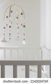 cute cloud mobile hanging on crib in nursery room - Shutterstock ID 2142024769