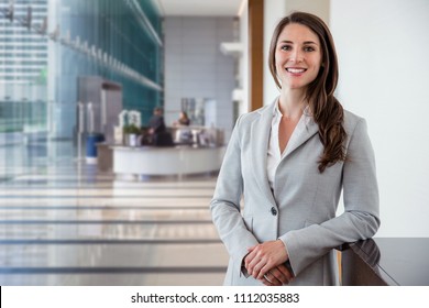 Cute Commercial Business Corporate Representative Woman Model Brunette Smiling In Large Building Hall Lobby