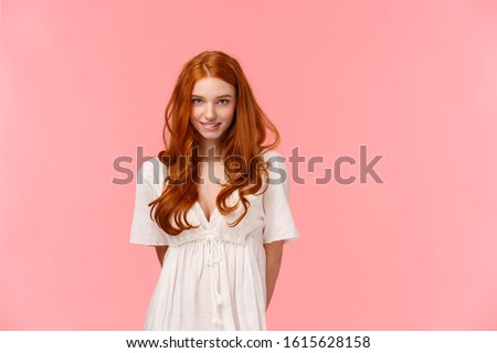 cute, coquettish redhead woman with seductive gaze, shy ask daring question, smiling waiting for reply, being on romantic date, standing pink background seductive