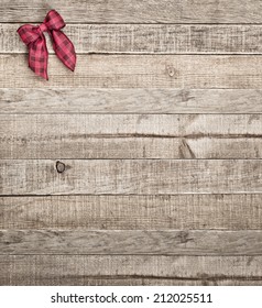 Cute Country Checked Christmas Bow On Rustic Board Background With Room Or Space For Copy, Text, Words.  Vintage Bleach Bypass Treatment On Vertical That Can Be Cropped To Horizontal