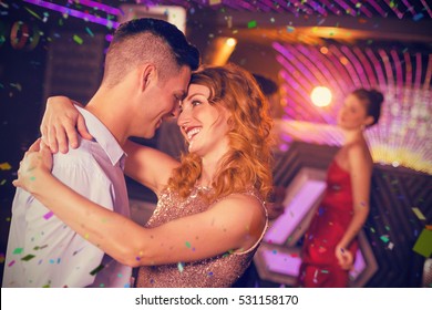 Cute Couple Dancing Together On Dance Floor Against Flying Colours