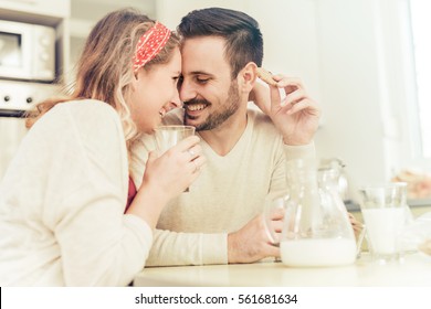 Cute couple having breakfast at home in the kitchen