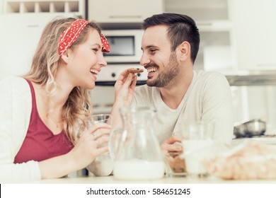 Cute couple having breakfast at home in the kitchen.