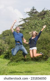 Cute couple jumping and smiling at home in the garden