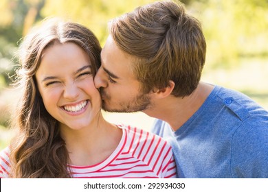 Cute couple kissing in the park on a sunny day