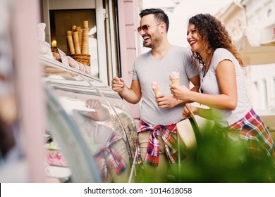 Cute Couple Laughing While Buying Ice Cream In The Ice Cream Shop. 