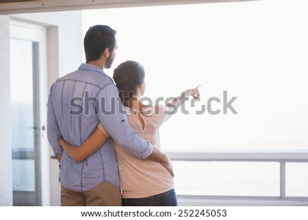 Cute couple looking out the window in their new home