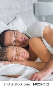 Cute Couple Sleeping And Spooning In Bed At Home In Bedroom