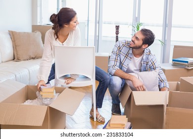 Cute couple unpacking cardboard boxes in their new home