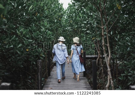 Cute couplewalking on thailand mangrove forest broadwalk