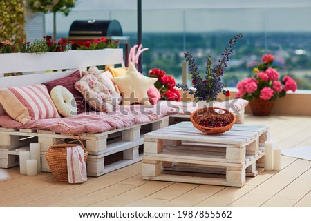 cute, cozy pallet furniture with colorful pillows at summer patio, lounge outdoor space Сток-фото © 