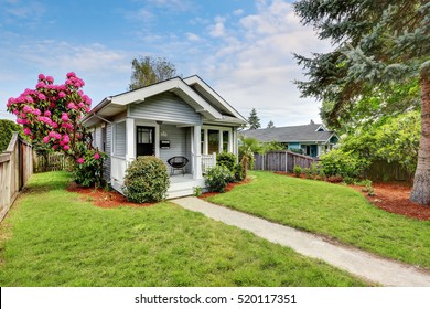 Cute Craftsman Home Exterior With Green Grass And Blooming Tree. Northwest, USA