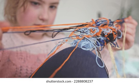 Cute Creative Caucasian Girl Trying to Untangle Hank Skein of Yarn