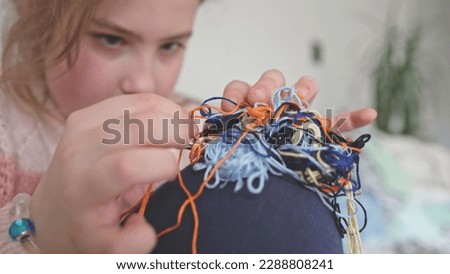 Cute Creative Caucasian Girl Trying to Untangle Hank Skein of Yarn