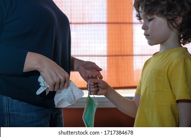 Cute curly child gives his mother a medical mask and gloves. - Shutterstock ID 1717384678