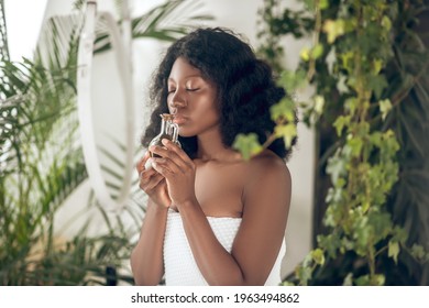 Cute dark-skinned young womna with essential oils in hand