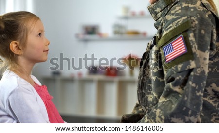Cute daughter looking with love at mother in military form, happy homecoming