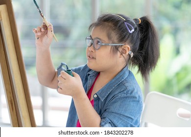 Cute Disability Kid Artist Enjoys Creative Painting Craft. Asian Special Girl Preschoolers Concentrate Pay Attention To Drawing Art In Classroom. Occupational Therapy Learning Disablilities Education.