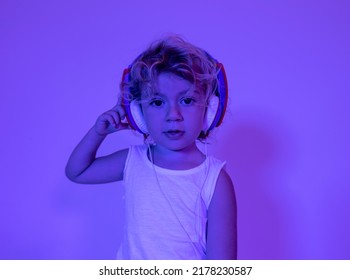 A cute djing small girl with headphones with coloured disco lighting