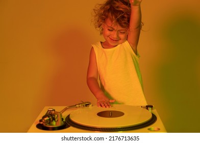 A cute djing small girl mixing vinyl on record player with coloured disco lighting